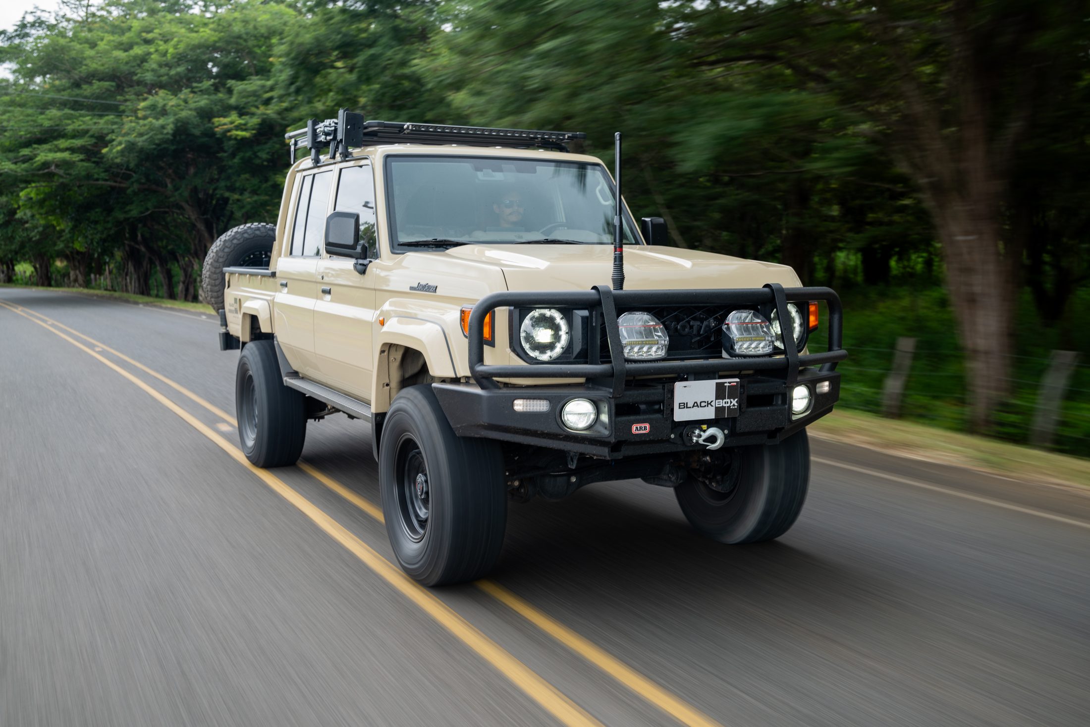 Beige Toyota Land Cruiser 70 driving towards the camera, car-to-car shot, photographed by Maxime Hugo